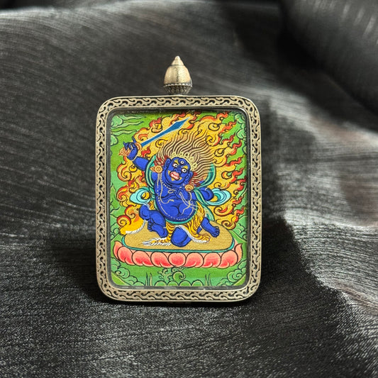 Hand-painted Acalanatha (Fudo Myo-o) mini thangka pendant from Rebgong featuring the blue Wisdom King with flaming halo and sword, painted with natural mineral pigments.