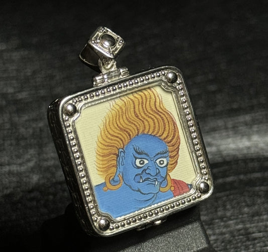 Close view of Acalanatha wrathful deity miniature Tibetan thangka pendant in silver frame