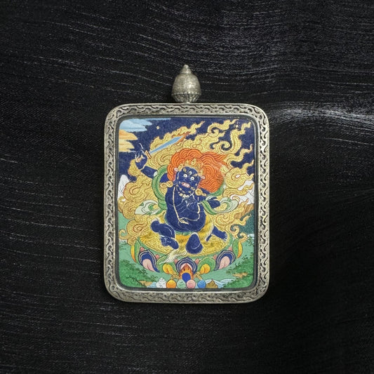 Front view of Acalanatha mini thangka pendant featuring hand-painted mineral pigment artwork in a traditional Tibetan silver protective case