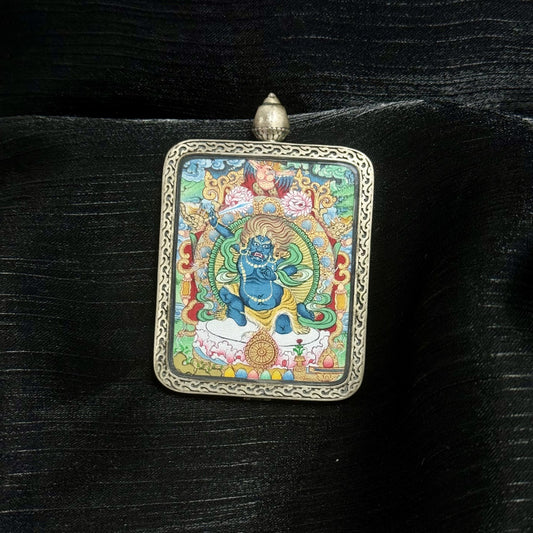 Front view of a hand-painted Acalanatha (Fudo Myo-o) mini thangka pendant set in a Dunhuang Nine-Color Deer silver gawu case, featuring mineral pigment layers, flame halo background, and detailed wrathful deity iconography.