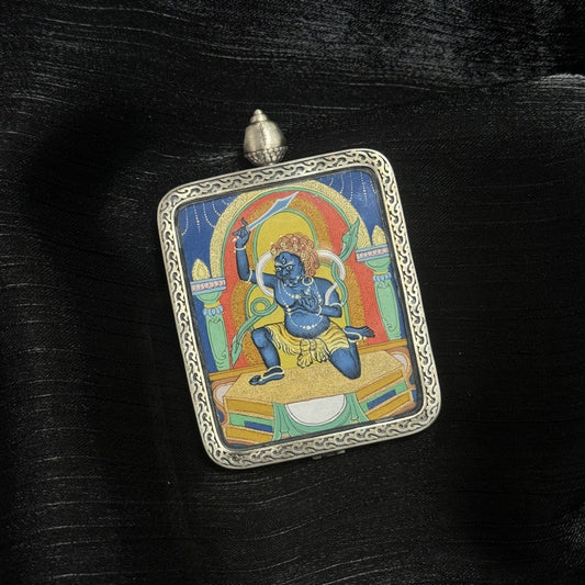 Close-up detail of hand-painted Acalanatha Thangka pendant showing mineral pigment layers and traditional Tibetan iconography