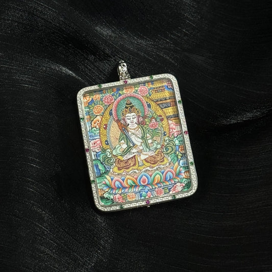 Front view of Akashagarbha Bodhisattva mini thangka pendant depicting the bodhisattva seated on a lotus throne with ornate halo, floral background, and detailed Tibetan decorative patterns.