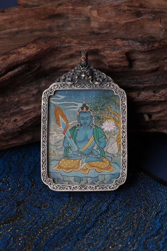 Close-up detail of Akashagarbha Bodhisattva mini thangka pendant, showing traditional Tibetan hand-painted mineral pigment artwork inside a vintage silver case
