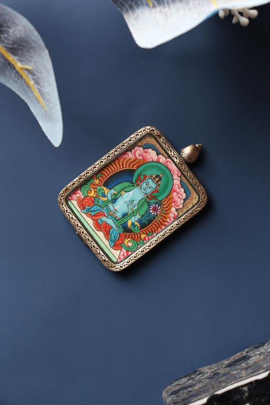 Front view of Akashagarbha Bodhisattva mini thangka pendant, hand-painted with natural mineral pigments and set in a Tibetan silver gawu-style case