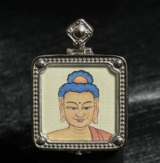 Close-up of a hand-painted Amitabha Buddha miniature thangka pendant, painted with mineral pigments and set in a detailed 925 silver plated frame.