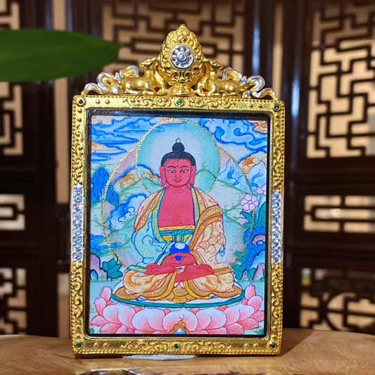 Front view of hand-painted Amitabha Buddha thangka in a gold-plated copper Gau pendant, showing a seated Buddha on a lotus throne with halo, clouds, and floral details