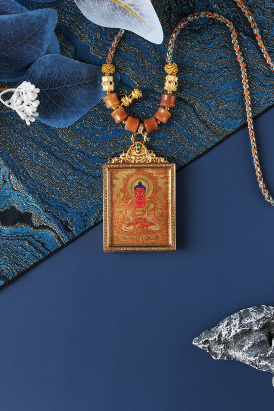 Hand-painted Amitabha Buddha mini thangka pendant featuring Rebgong gold thangka style, mineral pigment artwork, rectangular double-sided titanium steel case, and traditional braided cord details