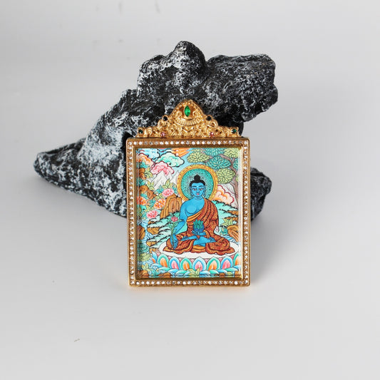 Front view of Bhaisajyaguru Buddha mini thangka pendant, hand-painted with mineral pigments, vivid layered colors, enclosed in a gold-tone double-sided jewelry-grade titanium steel case