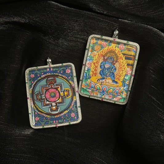 Front and back view of a Black Jambhala mini thangka pendant showing the wrathful wealth deity painted with mineral pigments and a detailed Tibetan mandala on the reverse side inside a decorative pendant frame.