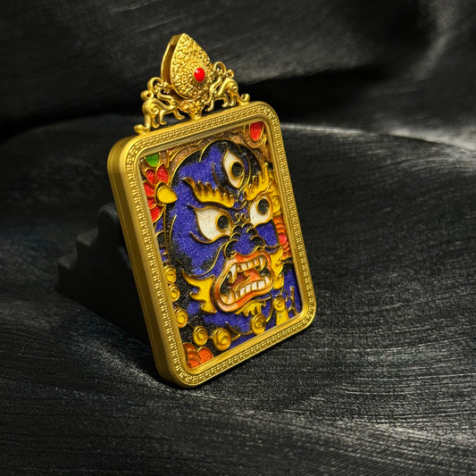 Angled close-up of Black Jambhala cloisonné enamel pendant highlighting gold wire cloisonné structure, colorful enamel details, and gold-plated copper protective frame