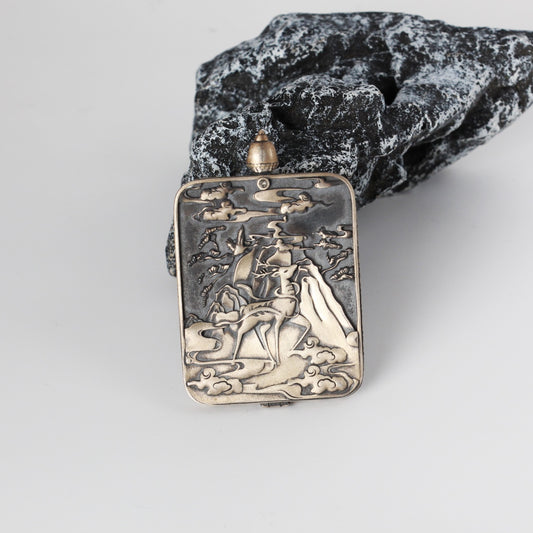 Back view of Green Tara mini thangka pendant showing the Dunhuang Nine-Colored Deer engraved silver case with cloud and mountain motifs