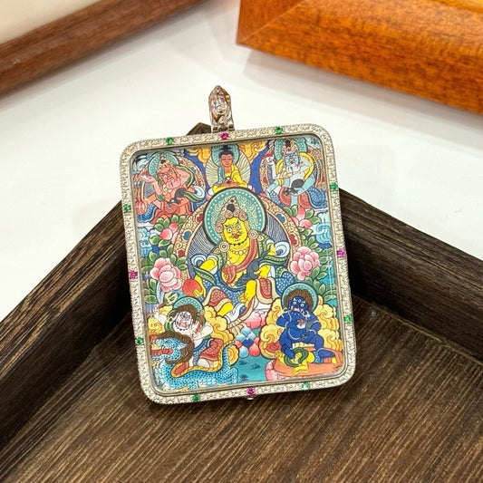 Close-up angled view of Five Jambhala mini thangka pendant focusing on the central Yellow Jambhala, surrounding four deities, intricate lotus flowers, and the silver gawu case edge with colored stone accents.