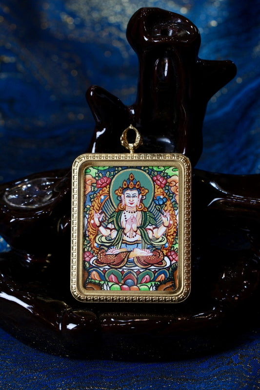 Close-up of Four-Armed Avalokiteshvara hand-painted mini thangka pendant in a gold-tone titanium-steel case
