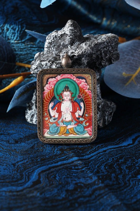 Four-Armed Avalokiteshvara Tibetan mini thangka pendant displayed upright, hand-painted with mineral pigments and set in a Dunhuang Nine-Color Deer pure silver gawu-style case.