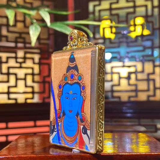 Side view of gold-plated copper gau pendant housing a hand-painted Akashagarbha Bodhisattva thangka