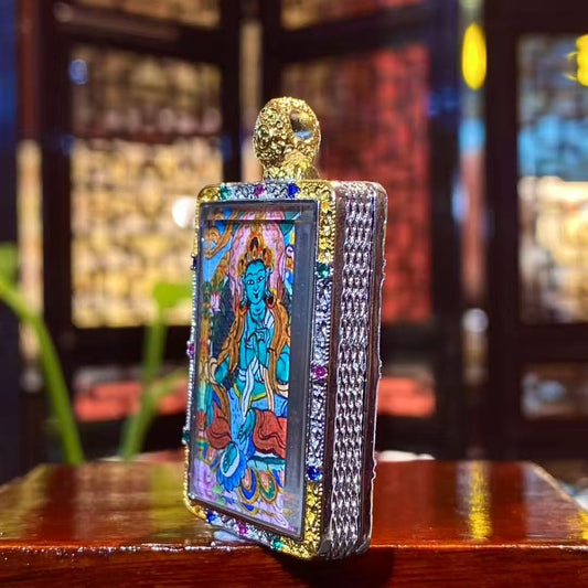 Side and frame detail of a Green Tara mini thangka pendant showing the copper Ghau box craftsmanship and decorative metal setting