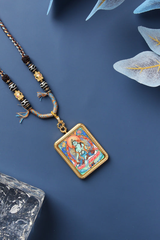 Green Tara mini thangka pendant featuring hand-painted Tibetan artwork from Rebgong, set in a titanium steel frame with traditional braided cord.