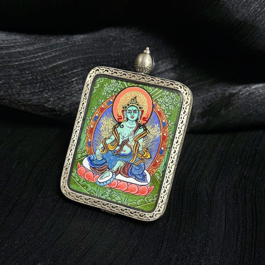Angled view of Green Tara mini thangka pendant showing hand-painted Rebgong thangka artwork with mineral pigments inside a 925 silver decorative frame