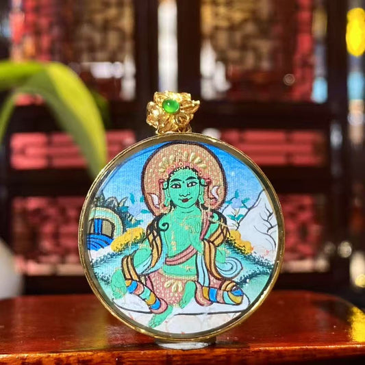 Front view of a round Green Tara Thangka pendant, hand-painted with 18K gold in Rebgong tradition, depicting Green Tara as a symbol of compassion and vitality.