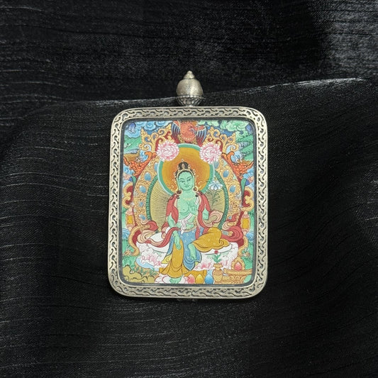 Hand-painted Green Tara Tibetan thangka pendant in Mentang style, featuring natural mineral pigments and a silver frame, symbolizing protection, compassion, and wisdom.