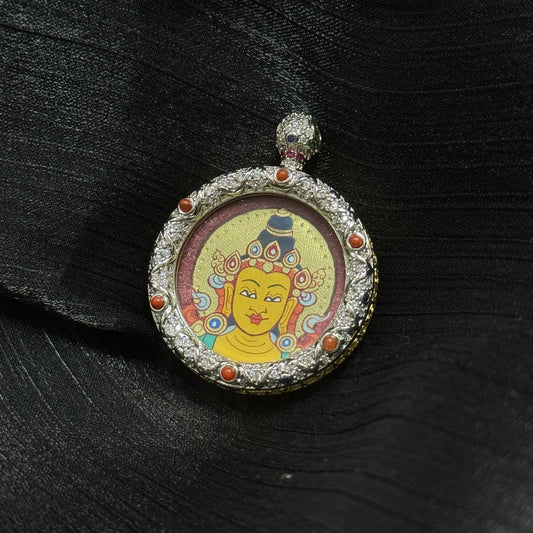 Close view of Manjushri Bodhisattva round miniature thangka pendant featuring red cinnabar background, gold halo details, and ornate jeweled copper pendant frame.