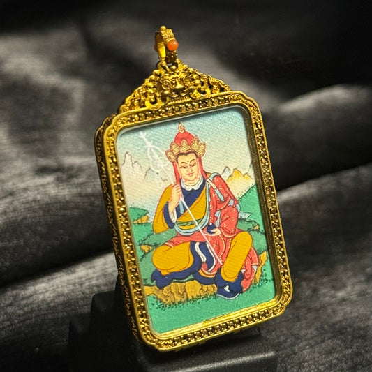 Front view of Ksitigarbha Bodhisattva mini thangka pendant, hand-painted with mineral pigments inside an ornate Tibetan copper protective case