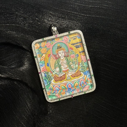 Close-up front view of the Mahasthamaprapta Bodhisattva mini thangka pendant featuring the serene bodhisattva seated on a lotus throne surrounded by intricate floral motifs and traditional Tibetan decorative patterns within a silver pendant frame.