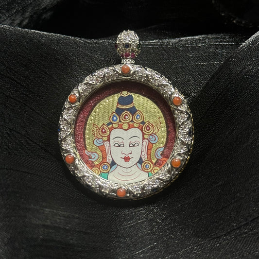 Close-up of Mahasthamaprapta Bodhisattva miniature thangka pendant showing hand-painted red and gold Buddha head with cinnabar mineral pigment background inside jeweled copper gawu frame
