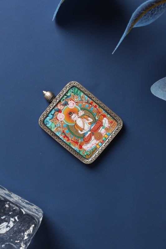 Angled view of a Mahasthamaprapta Bodhisattva mini thangka pendant featuring clean composition and strong lines, in a silver gawu-style case.