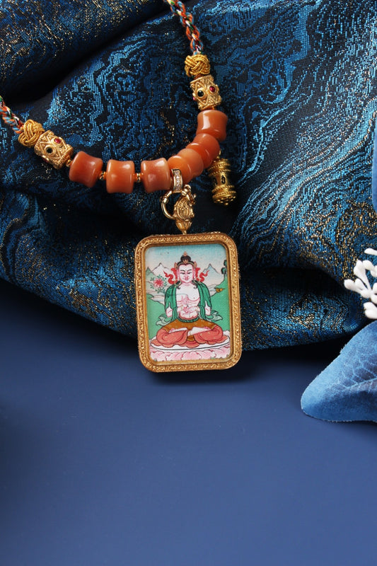 Mahasthamaprapta Bodhisattva thangka pendant laid flat, showing the rectangular pendant, braided cord, orange beads, metal bead elements, and small prayer wheel charm