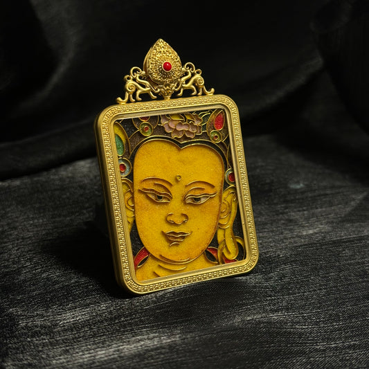 Angled view of a Manjushri cloisonné enamel mini thangka pendant highlighting the raised enamel design and gold-plated copper structure.