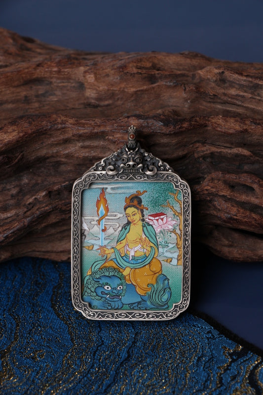 Close-up detail of Manjushri Bodhisattva mini thangka pendant, showing traditional Tibetan hand-painted mineral pigment artwork inside a vintage silver case