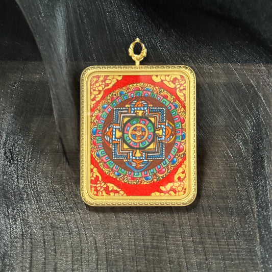 Hand-painted Nepal mandala mini thangka pendant featuring a detailed sacred geometry mandala with traditional mineral pigments on a red background, set in a square gold-tone frame with hanging loop.