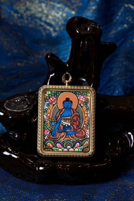 Hand-painted Nepalese Color Thangka Medicine Buddha pendant with titanium steel frame, front view, blue Medicine Buddha seated on lotus, 3.5 x 4.5 cm