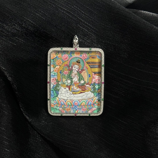 Front view of Samantabhadra Bodhisattva thangka pendant depicting the bodhisattva seated on a lotus with elephant mount, surrounded by floral motifs and detailed Tibetan decorative patterns.