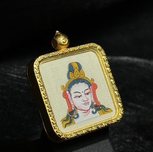 Angled view of a Samantabhadra Bodhisattva miniature thangka pendant featuring detailed hand-painted deity portrait and textured canvas inside a decorative gold-toned pendant frame.