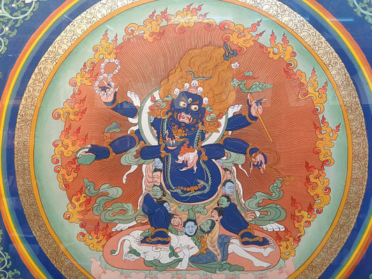 Detailed view of the Six-Armed Mahakala deity in a Tibetan mineral pigment thangka showing wrathful expression, flaming halo, and traditional iconographic posture.