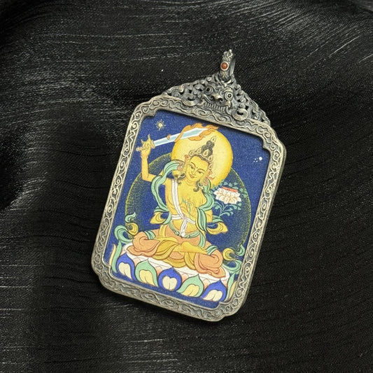 Front view of Manjushri Bodhisattva thangka pendant showing flaming wisdom sword, lotus base, golden halo, and layered mineral pigment texture.
