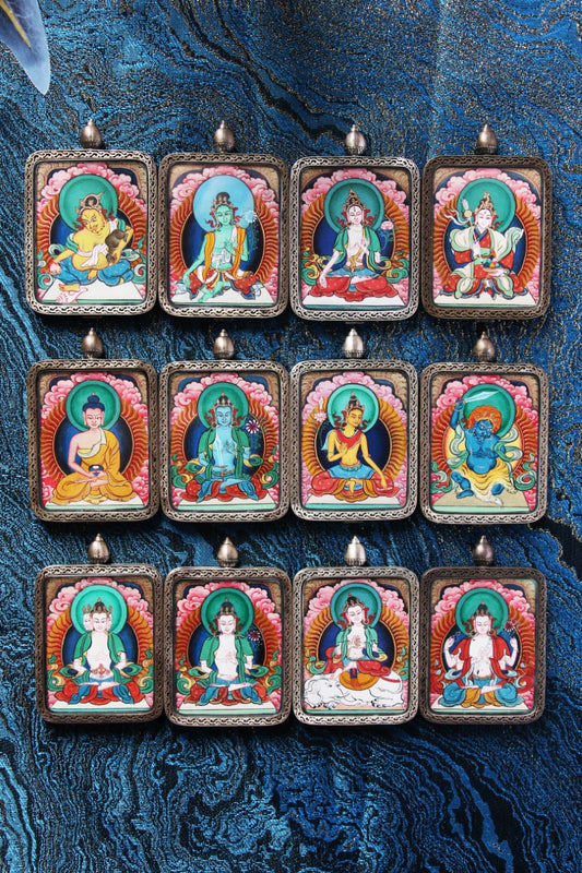 Group display of Tibetan Red Cloud Zangka Series mini thangka pendants, showcasing hand-painted mineral pigment artworks in silver protective cases for portable devotion and collecting.