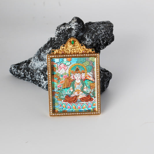 Front view of Vairocana Buddha hand-painted mini thangka pendant in a gold-tone double-sided jewelry-grade titanium steel case with crystal border and green top stone, Nepal style