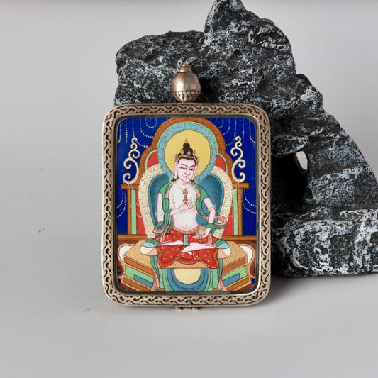 Front view of a Vajrasattva mini thangka pendant, hand-painted with mineral pigments on a deep blue background and set in an ornate square sterling silver case.