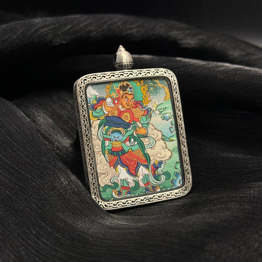 Angled view of Virupaksha Western Guardian King mini thangka pendant showing Tibetan hand-painted deity artwork in a silver pendant frame