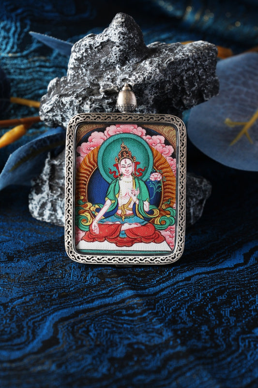 Close-up product photo of the White Tara mini thangka pendant highlighting hand-painted mineral pigment craftsmanship and the sterling silver protective case, ideal for collectors and practitioners seeking a durable portable thangka piece.