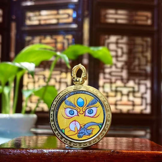 Front view of hand-painted Yellow Jambhala Thangka set in a titanium steel Tibetan Gawu pendant, God of Wealth amulet