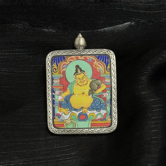 Front view of Yellow Jambhala mini thangka pendant, hand-painted with mineral pigments, featuring detailed Tibetan iconography and housed in a Dunhuang Nine-Color Deer silver gawu case.