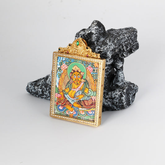 Side-detail view of Yellow Jambhala mini thangka pendant showing the raised titanium steel housing, crystal-style bezel frame, and structured pendant profile