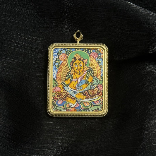 Close-up of Yellow Jambhala thangka pendant featuring the wealth deity holding a jewel and mongoose, painted with traditional mineral pigments and framed in a durable titanium steel pendant case.