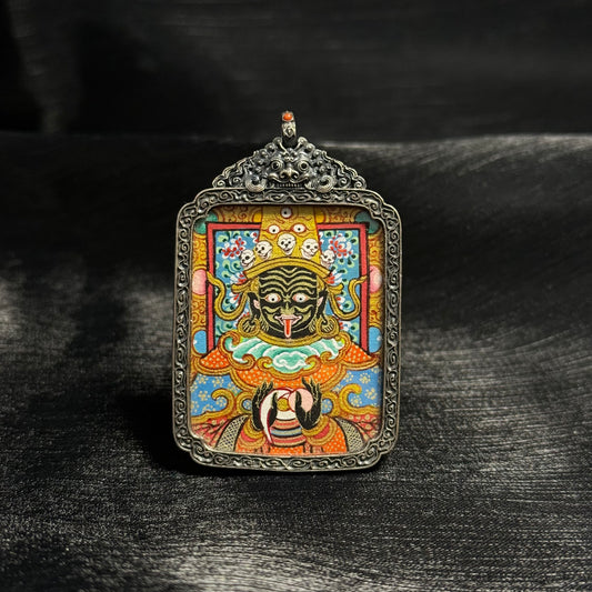 Front view of Zaki Lhamo mini thangka pendant featuring a hand-painted Tibetan protective goddess using mineral pigments and gold powder, set in an ornate silver frame.