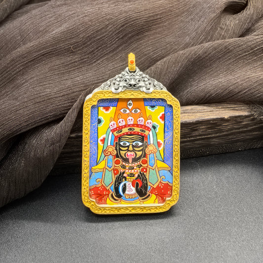 Front view of Zaki Lhamo mini thangka pendant featuring a blue background deity portrait, hand-painted with mineral pigments in the Rebgong style, set inside an ornate pendant frame.
