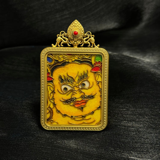 Handcrafted Yellow Jambhala cloisonné enamel mini thangka pendant with 24K gold-plated copper case, front view showing detailed wealth deity face and traditional Tibetan decorative frame.